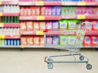 detergent shelves in supermarket or grocery store with empty shopping cart