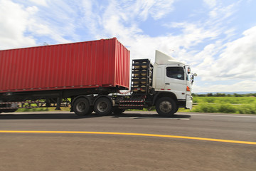 Wall Mural - Red truck on the highway under the blue sky