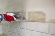 © artursfoto - Process of tiling the tiles in the kitchen. Home improvement, renovation concept