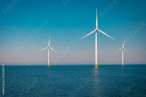 Fotografie, Obraz Offshore and Onshore Windmill farm in the ocean ,windmills isolated at sea on a
