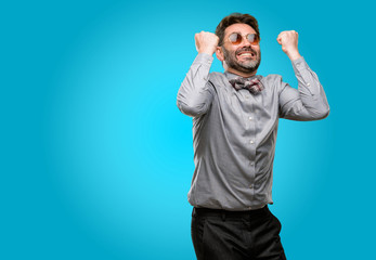 Wall Mural - Middle age man, with beard and bow tie happy and excited celebrating victory expressing big success, power, energy and positive emotions. Celebrates new job joyful