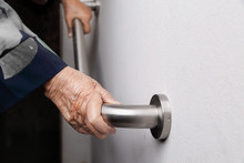 Elderly Woman Holding On Handrail For Safety Walk Steps