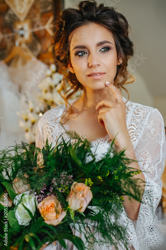 The Bride In A Beautiful Lace Robe With A Bouquet Of Flowers And