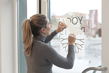 Woman Applying Company Logo Film On Window