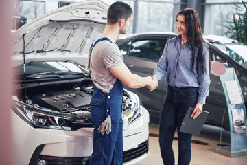 husband car mechanic and woman customer make an agreement on the repair of the car