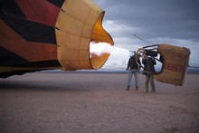 Two Men Flying A Hot Air Balloon In A Dry Lake Bed
