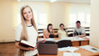 © andrey_orlov - Female college student in a classroom holding a notebook