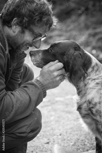 Fotografía man's affection for his english setter dog in black and white