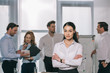 © LIGHTFIELD STUDIOS - selective focus of businesswoman and colleagues behind at white board in office