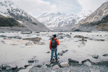 Wall Mural - Tourist standing at the edge of Hooker glacier lake with the scenery view of Mt.Cook the highest mountains in New Zealand.