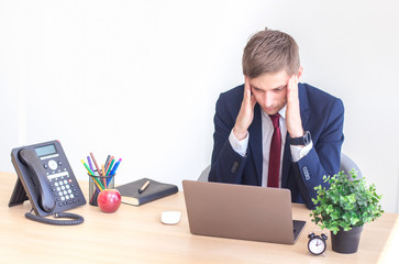 Frustrated stressed business man working on laptop computer at the office.