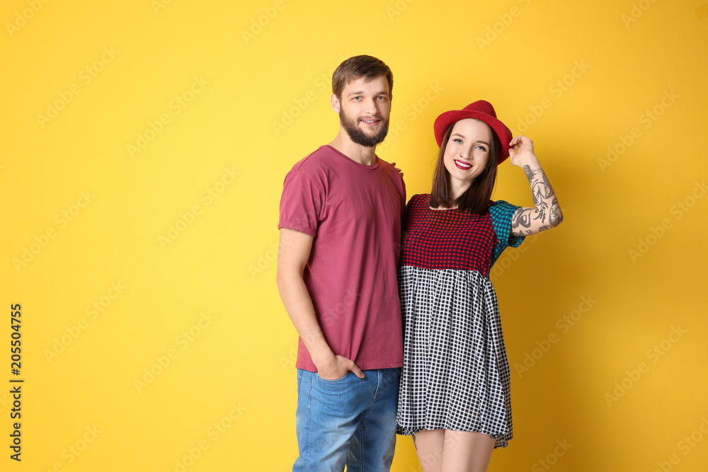 Trendy hipster couple posing together against color background