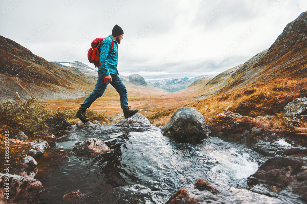 Man solo traveling backpacker hiking in scandinavian mountains active healthy lifestyle adventure journey vacations - obrazy, fototapety, plakaty 