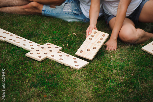 Fotografía Young man and woman playing giant dominoes in the Park on the grass