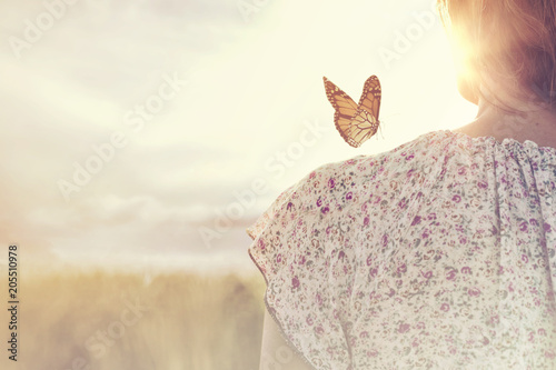 Fotomural special moment of meeting between a butterfly and a girl in the middle of nature