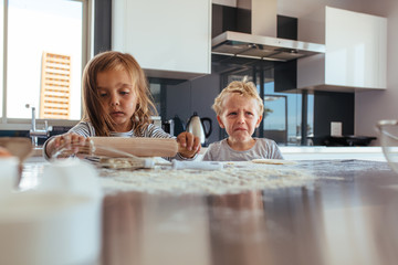 Wall Mural - Little girl making cookies and boy crying in kitchen