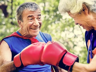 Childlike seniors wearing superhero costumes