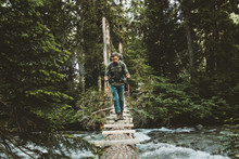 Man Traveler Crossing River On Log Bridge Outdoor Survival Lifestyle Travel Concept Adventure Vacations Wild Forest Wanderlust