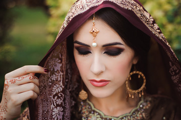 Wall Mural - Portrait of beautiful indian girl . Young hindu woman model with tatoo mehndi and kundan jewelry.