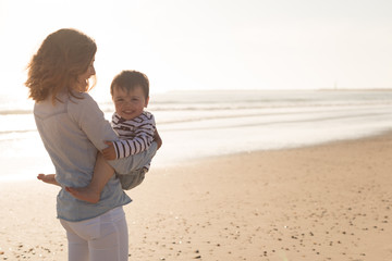 Wall Mural - mother at the beach with her baby