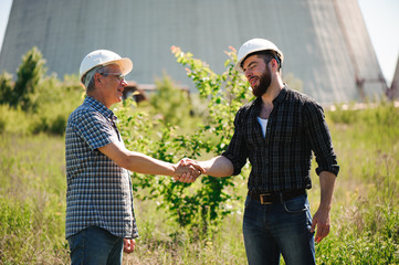 Wall Mural - two power line tower workers with handshaking