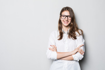 Smiling business woman with folded hands against white background. Toothy smile, crossed arms.