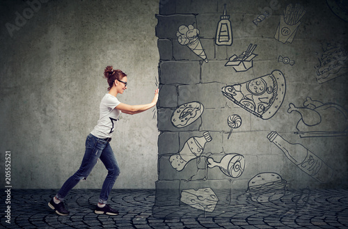 Cuadros en Lienzo motivated woman resisting temptation of eating fast foot and choosing better die