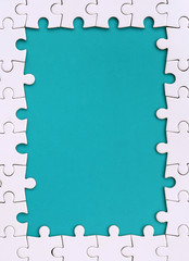 Framing in the form of a rectangle, made of a white jigsaw puzzle around the blue space