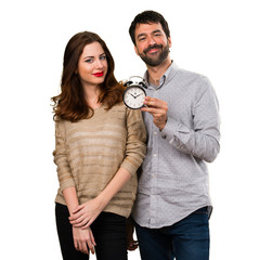 Young couple holding vintage clock