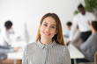 © fizkes - Attractive woman business leader smiling looking at camera headshot portrait, beautiful elegant businesswoman, successful professional female boss or company executive manager coach posing in office