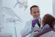 © Viacheslav Yakobchuk - Dental therapist. Cheerful male dentist wearing uniform while examining patients teeth