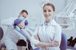 © Viacheslav Yakobchuk - Ready for work. Inspired glad female dental assistant crossing arms and smiling to camera