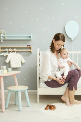 Wall Mural - 

Mother or baby sitter speding time with adorable baby girl in the kid's bedroom