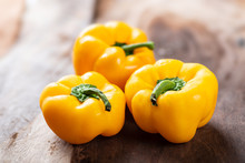 Yellow Bell Peppers Or Sweet Peppers On Wooden Background