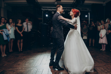 Wall Mural - happy bride and stylish groom dancing at wedding reception. gorgeous wedding couple performing their first dance in restaurant. newlyweds, happy emotional moment. space for text