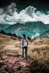 Wall Mural - young woman backpacking in the mountains
