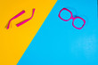 © Sebastian - Studio shot of pink sunglasses. Summer is coming concept. Minimal style, minimalist photography. Top view of spread sunglasses on colorful paper backdrop. Yellow and blue pastel colors.