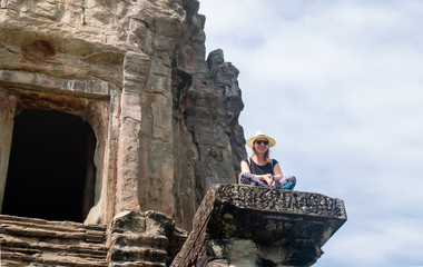 tourist girl sitting at the temple angkor wat in cambodia