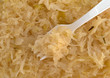 Close view of canned sauerkraut with a fork in the food.