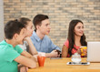 © Africa Studio - Group of cool teenagers with modern devices resting in cafe
