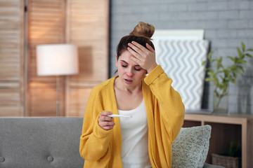 Wall Mural - Sick woman with thermometer suffering from cold on sofa at home