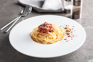 Plate with delicious pasta bolognese on table