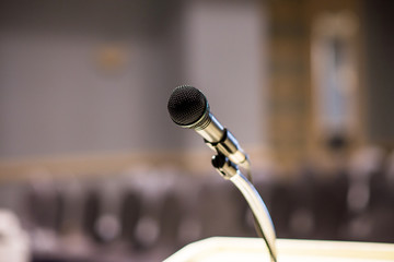 Microphone on blurred in seminar room or conference hall background