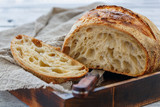 Cut loaf of artisanal wheat bread on sourdough.