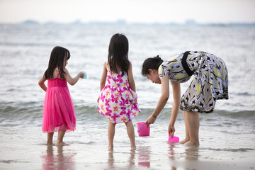 Wall Mural - Asian Chinese mum and daughters playing sand together