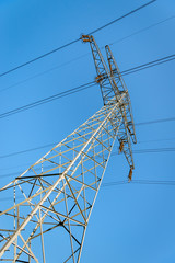 Wall Mural - Electricity pylon with wires against a blue sky