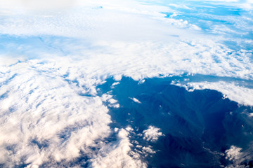 Wall Mural - blue sky and cloud and mountain top view from airplane window,nature background