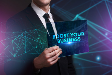 Business, Technology, Internet and network concept. Young businessman working on a virtual screen of the future and sees the inscription: Boost your business