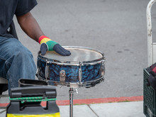 Drummer Beats On Steel Drum On Sidewalk In A Street Performance