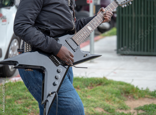 Fotografie, Obraz Street musician strumming an electric guitar in an outdoor performance